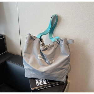 Detail of grey canvas tote bag with teal straps and Dream together Remember Love print