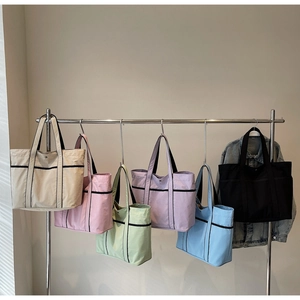 Macro shot of minimalist tote bags in multiple colors with black trim detailing