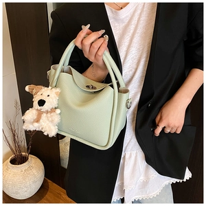 Détail du sac seau vert menthe avec texture litchi et pendentif ours en peluche