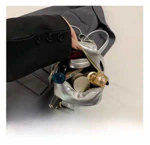 Internal capacity of silver mini backpack showing makeup storage and gold hardware