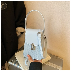 Close-up of light blue croc-embossed leather handbag with silver metallic lock detail