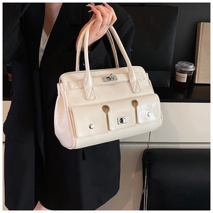 Détail du sac à main blanc crème avec finition brillante et fermoirs métalliques argentés