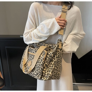 Detail of leopard print tote bag with front zip pocket and round logo patch