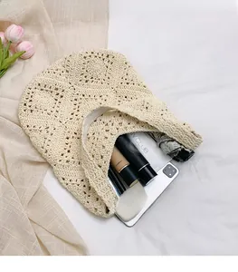 Détail du grand sac de plage au crochet contenant tablette, parapluie et cosmétiques