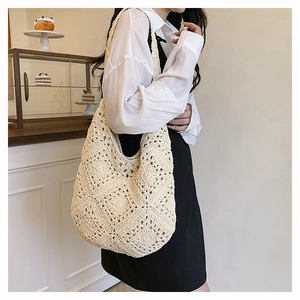 Détail d'un grand sac hobo en crochet beige avec motifs de losanges évidés tissés main