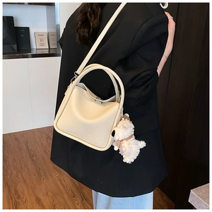 Sac à main chic en cuir grainé blanc crème avec un pendentif chien en peluche