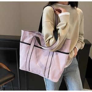 Lifestyle view of a large lilac tote bag with black contrast handles for daily commute