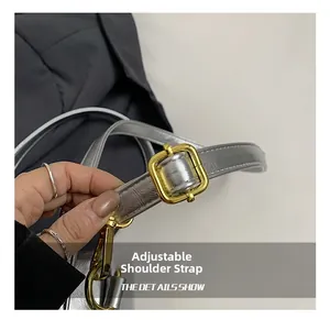 Close-up of adjustable silver strap with gold metal buckle on casual faux leather bag