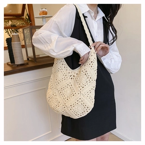 Détail du motif au crochet blanc crème et texture florale ajourée du grand sac de plage