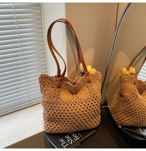Dettaglio borsa tote traforata con manici in pelle marrone per vacanze estive al mare