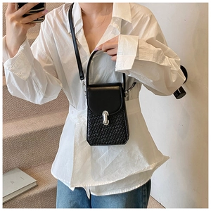 Close-up of black crossbody bag featuring woven texture and silver metal buckle detail