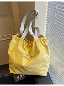 Minimalist yellow drawstring canvas tote bag with purple Dream Together printed lettering