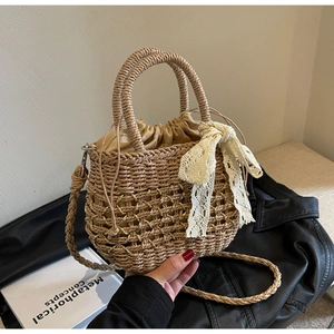 Détail du sac en paille tressée avec nœud en dentelle et doublure sur livre d'art