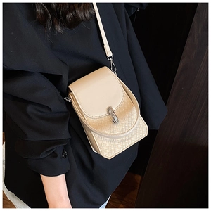 Detail view of beige crossbody phone bag featuring woven texture and silver metal buckle