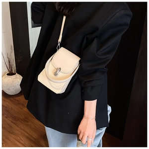 Beige mini crossbody phone bag with animal texture on a model wearing a black blazer
