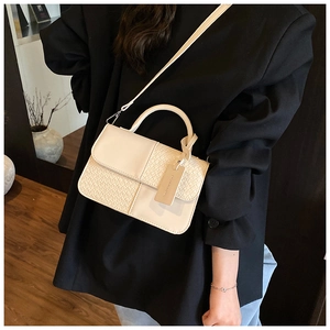 Détail du sac à main beige présentant un mélange de similicuir lisse et de texture tissée