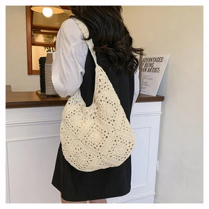 Détail du sac hobo en crochet crème avec motifs floraux dans un décor de café chic