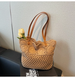 Dettaglio della trama intrecciata a mano e dei manici in ecopelle marrone di una borsa mare