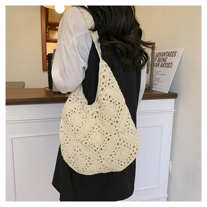Détail du sac à bandoulière en crochet beige à motif floral porté par un mannequin