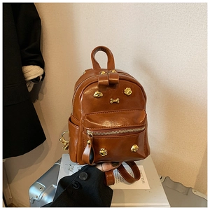 Detailed view of brown PU leather backpack with gold dog paw and bone shaped studs