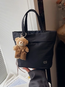 Quilted black tote bag with COIN 2DN logo and cute plush bear charm decoration