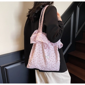 Detailed close-up of a pink floral tote bag featuring elegant ruffled edges and textures