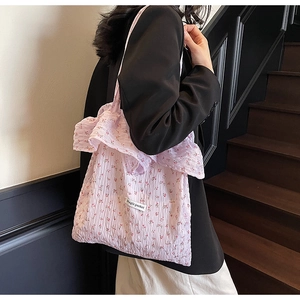 Side view of floral tote bag with ruffles and Magic pocket label on dark stairs