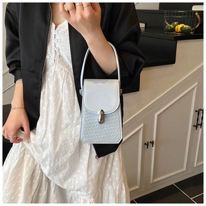 Detail of light blue mini handbag with silver metallic clasp and embossed crocodile texture