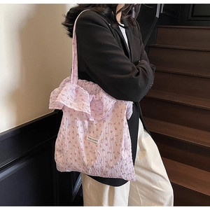 Close-up of floral tote bag with ruffled edges and Magic Pocket fabric label