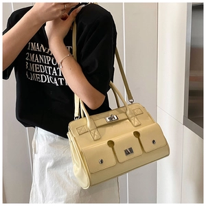 Détail du sac à main rétro jaune crème en cuir avec trois poches à boucle métallique