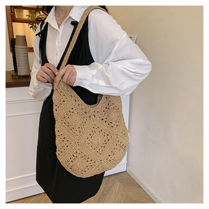 Gros plan détaillé du sac à bandoulière au crochet beige avec motifs floraux ajourés