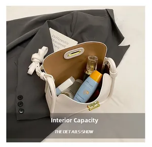 Detail view of large capacity white litchi leather bag with brown lining and cosmetics