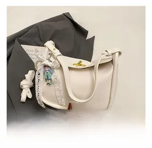 Detail of white litchi pattern tote with gold turn-lock and cute doll decoration
