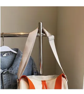 Détail du sac seau en toile avec poignées orange et bandoulière large réglable