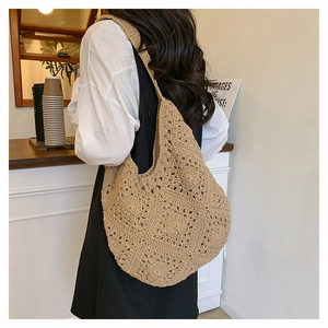 Sac à bandoulière en corde de coton tressé kaki porté par un mannequin dans un café