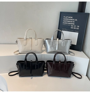 Polished leather bucket bags in beige, silver, black and brown on white stairs