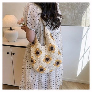 Détail du sac à bandoulière au crochet avec tournesols porté avec une robe à fleurs chic