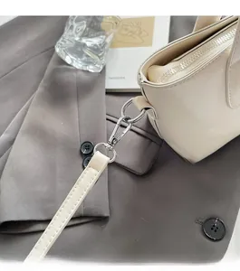 Detailed macro of beige PU leather tote with silver hardware and stitching details