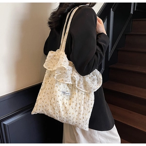 Detail of floral tote bag with ruffle trim and Magic pocket label in soft cream cotton