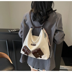 Détail du sac cabas blanc avec poches marron, lanières en cuir et foulard en soie rayé