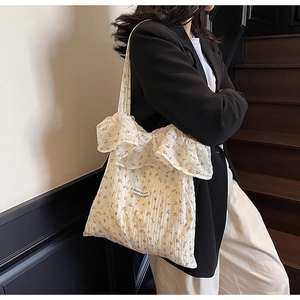 Close-up of floral tote bag featuring yellow flower patterns and ruffle edge detail