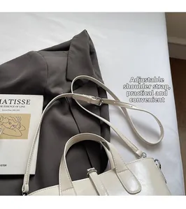 Detail of off-white bucket bag with adjustable shoulder strap and leather texture