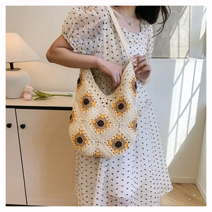 Détail du sac fourre-tout au crochet fait main avec motifs de tournesol et texture tricotée
