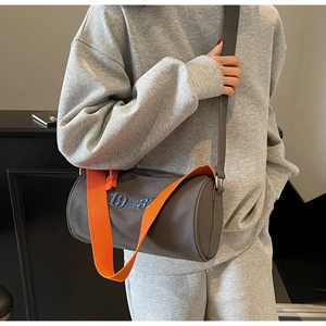 Sac cylindrique en toile grise avec bandoulière orange et broderie bleue 1988