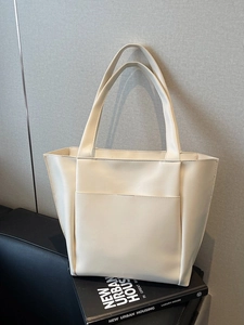 Minimalist off-white leather tote bag with functional front pocket for urban commuting