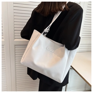 Close-up of white lychee texture leather tote bag with FASHION & BAG label detail