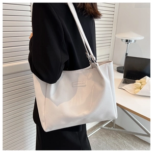 Close-up of a cream-white pebbled leather tote bag with FASHION & BAG lettering