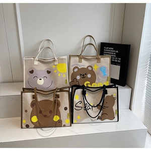 Détail de quatre sacs fourre-tout en toile avec oursons mignons sur escalier en marbre