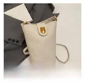 Nahaufnahme der weißen Beuteltasche mit Litschi-Textur und goldenem Metallverschluss