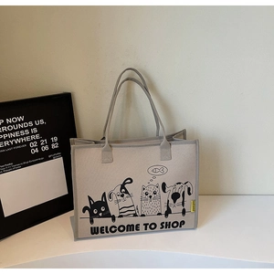 Detailansicht der Filztasche mit Cartoon-Druck und Text auf einem minimalistischen Tisch